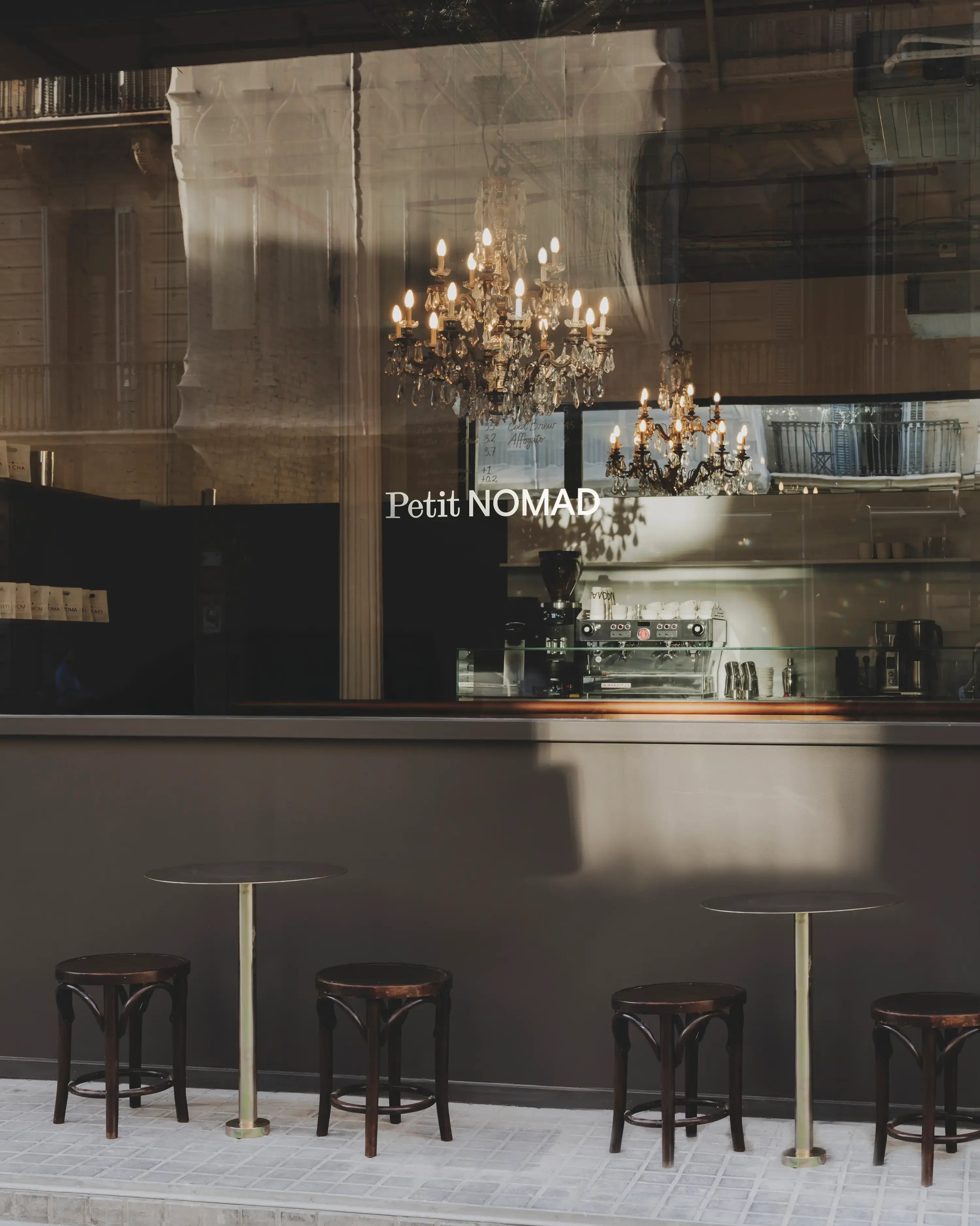 Petit NOMAD coffee bar viewed through its storefront window in Barcelona